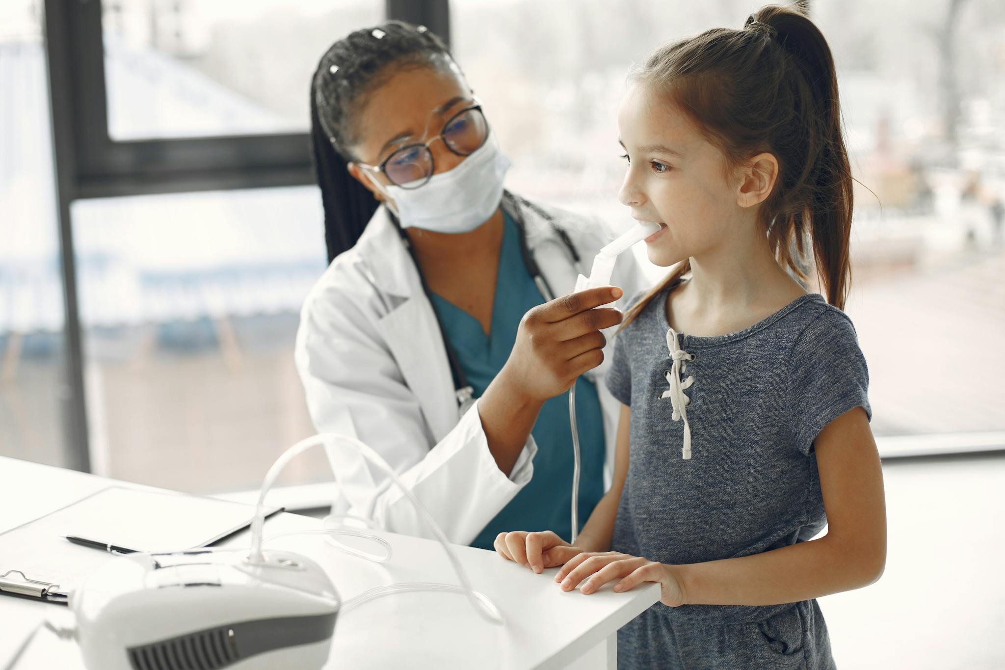 A female doctor examines a young girl in a medical office.