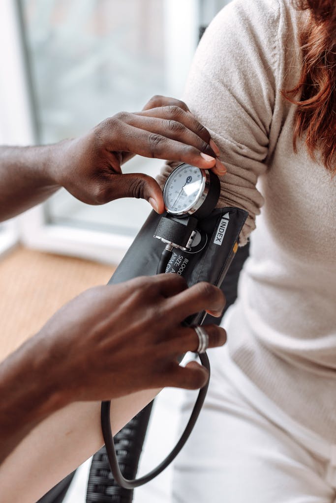 Healthcare professional using blood pressure monitor on patient during check-up.